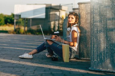 Kadın kaldırımda dizüstü bilgisayar kullanarak