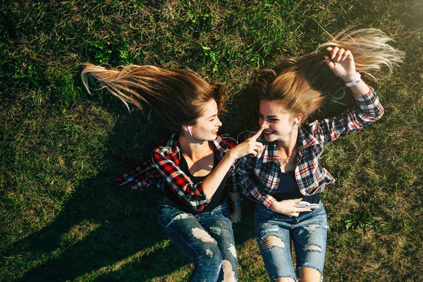 Hermanas tumbadas en la hierba en el parque — Foto de Stock