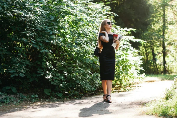 Mulher de vestido preto no parque de verão — Fotografia de Stock