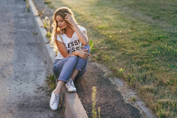 Mulher sentada no lado da estrada — Fotografia de Stock