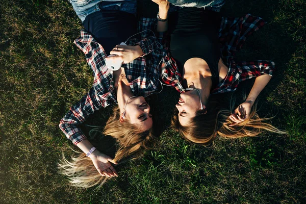 Hermanas tumbadas en la hierba en el parque — Foto de Stock