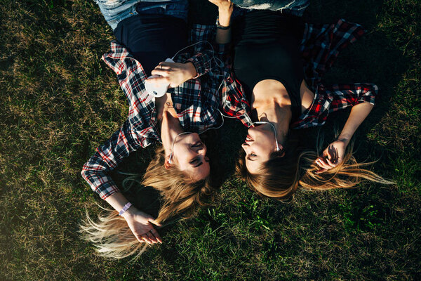 sisters lying on grass in park