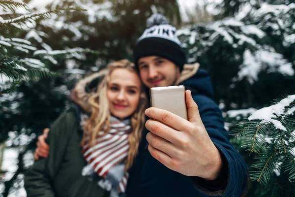 Casal tomando selfie no parque nevado — Fotografia de Stock