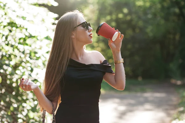 Donna con caffè nel parco — Foto Stock