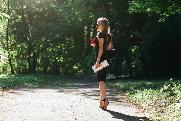 Mulher de vestido preto no parque de verão — Fotografia de Stock