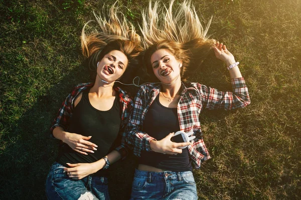 Сестры лежат на траве в парке — стоковое фото