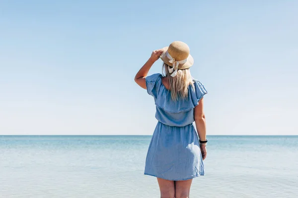 Жінка з солом'яним капелюхом на морі — стокове фото