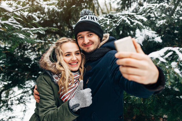 couple taking selfie in snowy park