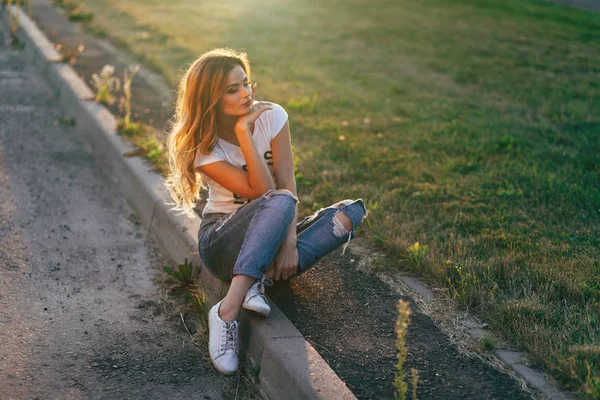 Kvinnan sitter på trottoaren — Stockfoto