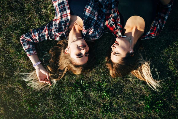 Сестры лежат на траве в парке — стоковое фото