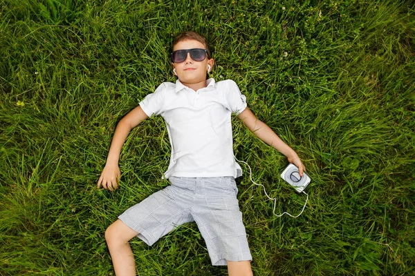 Menino Óculos Sol Deitado Chão Ouvindo Música Fones Ouvido — Fotografia de Stock