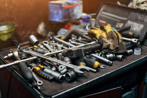 Wrenches, protective gloves, hammer, etc. Closeup of engineer workplace