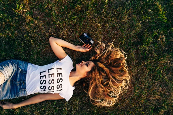 woman lying on lawn with camera