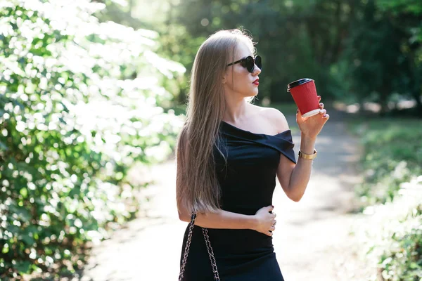 Donna con caffè nel parco — Foto Stock