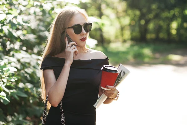 Donna che tiene il caffè e parla al telefono — Foto Stock