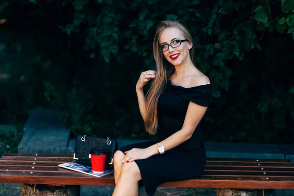 Frau sitzt auf Bank im Park — Stockfoto