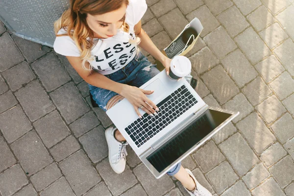 Woman on pavement using laptop — Stock Photo, Image