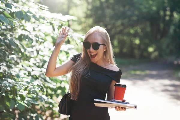 Donna con riviste e caffè nel parco — Foto Stock