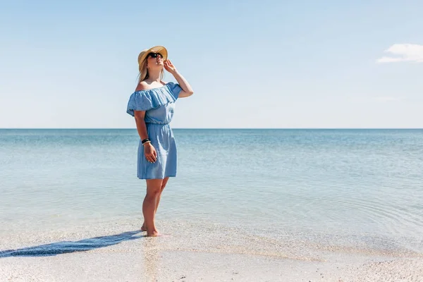 Woman in straw hat on beach — Stock Photo, Image