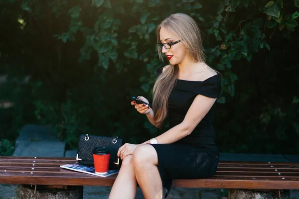 Mulher no banco usando smartphone — Fotografia de Stock