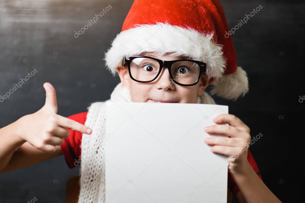 boy in Santa hat holding card
