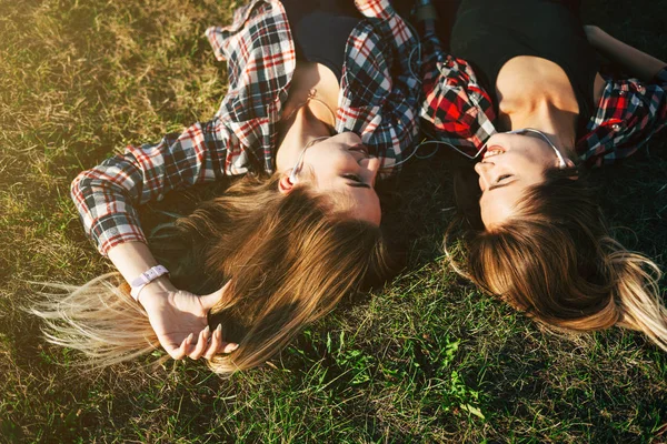 Hermanas tumbadas en la hierba en el parque — Foto de Stock