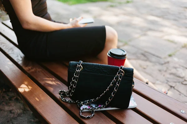 Mulher sentada no banco com café e bolsa — Fotografia de Stock