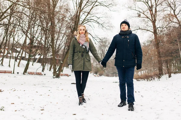 Casal de mãos dadas no parque nevado — Fotografia de Stock