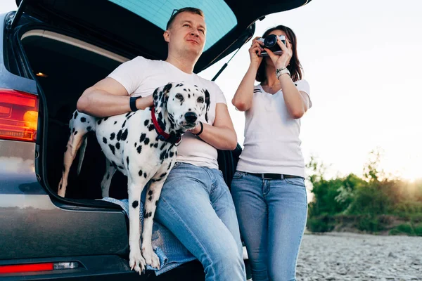 Portrait de couple heureux de jeunes adultes avec chien en voyage. Hommes s — Photo