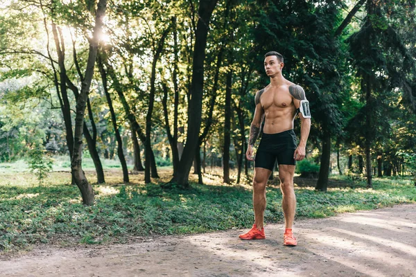 Jovem atleta caucasiano em tatuagens, treinando ao ar livre e posando — Fotografia de Stock