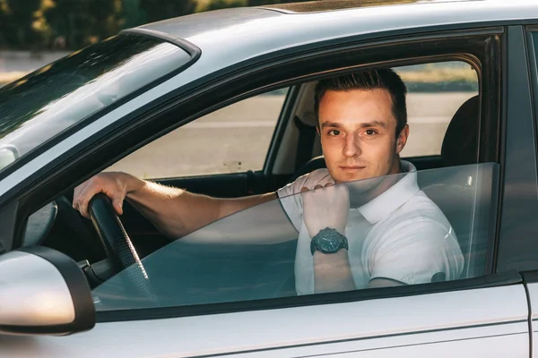 車の中で座っている白い t シャツの若い魅力的な白人男性 — ストック写真