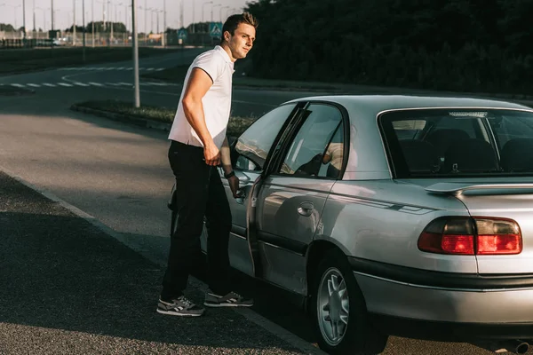 Fiatal vonzó kaukázusi Férfi fehér póló áll az autóval — Stock Fotó