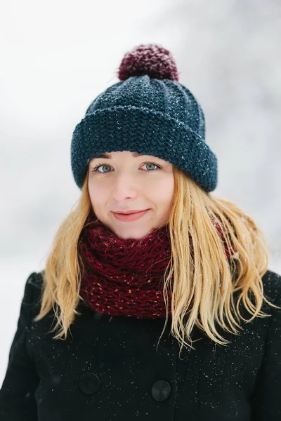 Giovane ragazza bionda caucasica in cappotto nero e rosso a maglia sciarpa passeggiate nel parco invernale — Foto Stock