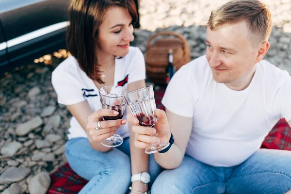 Portrait de couple heureux de jeunes adultes en voyage. Homme assis sur plaid avec une femme. Concept de pique-nique extérieur . — Photo