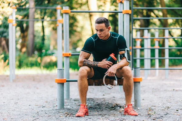 Jonge Kaukasische atleet in tatoeages, opleiding outdoor en poseren — Stockfoto