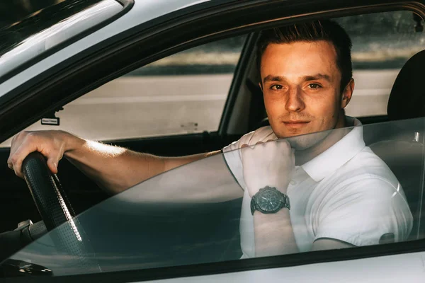 車の中で座っている白い t シャツの若い魅力的な白人男性 — ストック写真