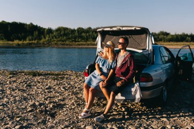 Mutlu traveler çift ayakta car yakınındaki Bagajı açın ve güneşin doğuşunu izlemek
