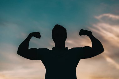 Gün batımı arka planda genç bir adam silüeti