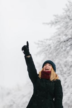 Siyah palto ve kırmızı örme eşarp genç Beyaz sarışın kız kış parkta yürüyor