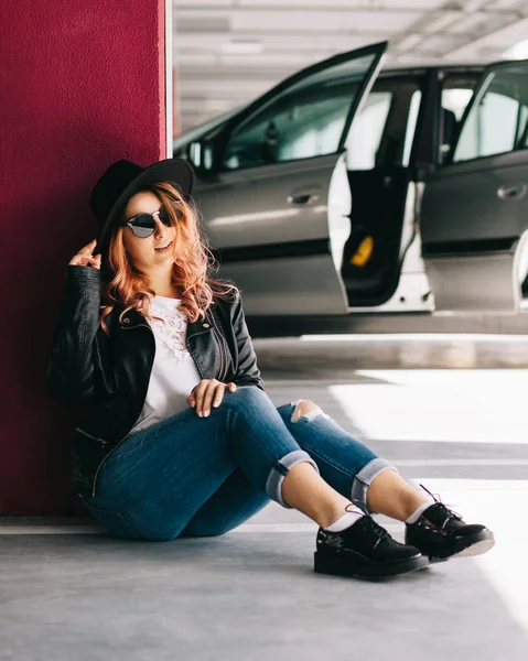 Портрет молодой стильной женщины, позирующей на парковке — стоковое фото