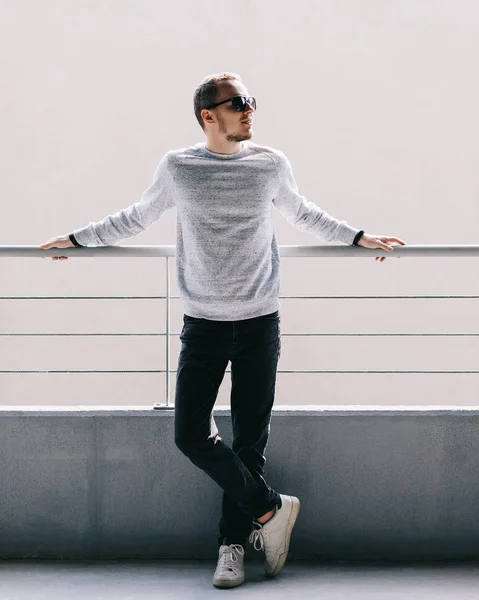 Retrato de homem bonito jovem em suéter branco e óculos de sol pretos — Fotografia de Stock