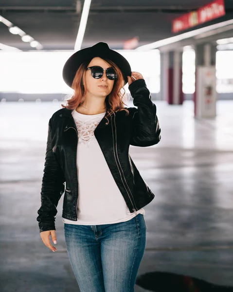 Porträt einer jungen, stylischen Frau, die auf einem Parkplatz posiert — Stockfoto