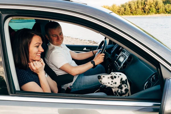 幸福的年轻夫妇与狗在 roadtrip 的肖像。男人和女人坐在格子上户外野餐概念. — 图库照片