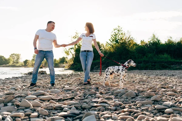 Ritratto di giovane coppia adulta felice con cane in viaggio. Uomo seduto su un plaid con una donna. concetto di picnic all'aperto . — Foto Stock