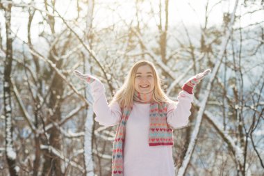 Genç beyaz çekici sarışın kız pembe kazak ve örme eşarp kış Park'ta açık tutar