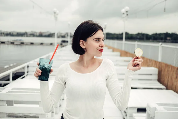 Närbild Porträtt av vacker Brunett flicka i vit tröja Drycker Cocktail i Café Nära sjön — Stockfoto