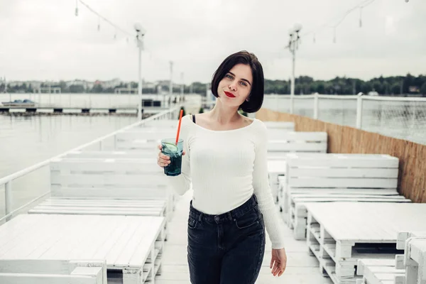 Close Up Ritratto di bella ragazza bruna in maglione bianco beve Cocktail nel caffè vicino al lago — Foto Stock