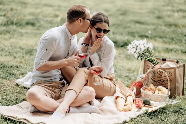 Pareja feliz joven vestida como en camiseta blanca divirtiéndose en el picnic, fin de semana fuera de la ciudad, concepto de vacaciones — Foto de Stock