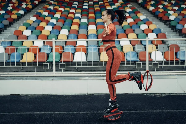 Portrait of One Sports Fitness Girl Dressed Fashion Sportswear Outfit Doing Kangoo Jumps Exercise and Training at the City Stadium, Healthy Lifestyle Concept — Stock Photo, Image