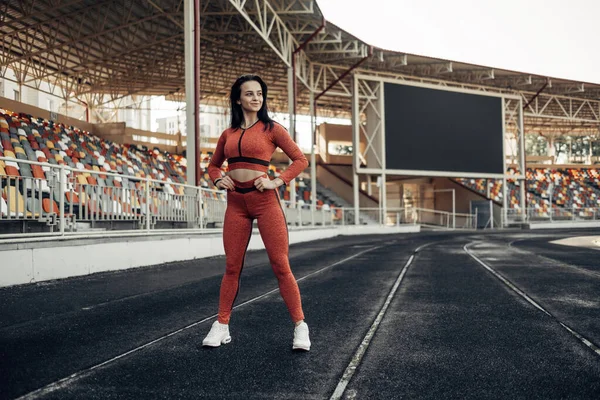 Retrato de una chica deportiva vestida con ropa deportiva haciendo ejercicio y entrenamiento en el estadio de la ciudad, concepto de estilo de vida saludable — Foto de Stock